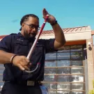 Abiel Malepeai with his fraternity cane outside the UC Davis Fire Department.