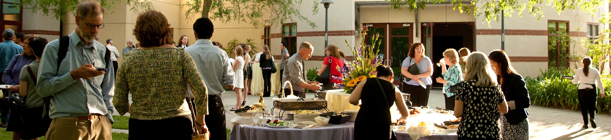 An event with catered food and people walking and talking about at the Moss Garden.